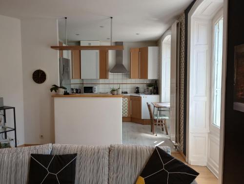 un salon avec un canapé et une cuisine dans l'établissement Tulle : bel appartement lumineux en centre ville, à Tulle