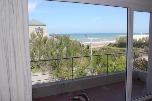 a room with a balcony with a view of the beach at Casa De Alta Categoría Ubicada En Barrio Medanos Frente Al Mar in Necochea