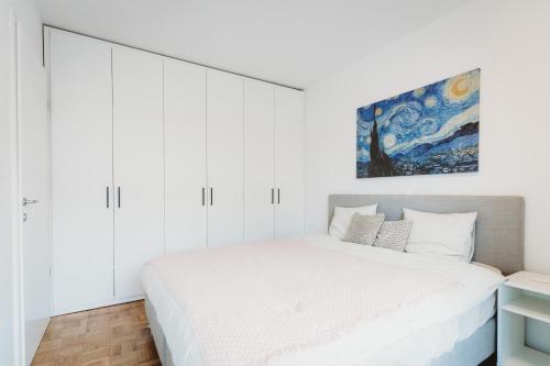 a bedroom with a large bed with white cabinets at Peaceful Little Retreat, spacious free garage park in Ljubljana