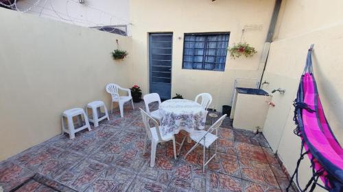 een patio met een tafel en stoelen en een gebouw bij Kitnet confortável em paulinia in Paulínia