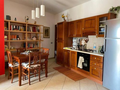 eine Küche mit einem Tisch und einem Kühlschrank in der Unterkunft Casa~Lu in Mentana