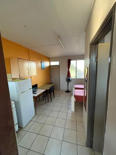 a small kitchen with a table and a refrigerator at JCM locations in Les Trois-Îlets