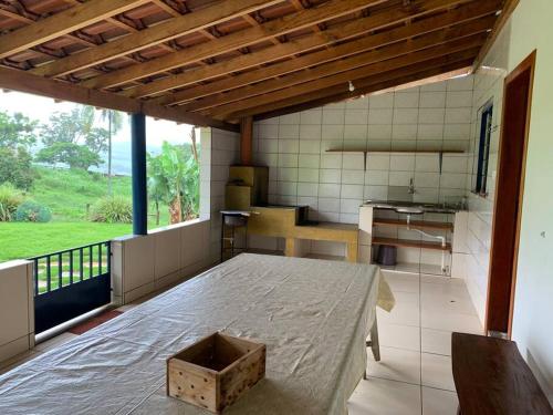 een kamer met een bed in een kamer met een keuken bij Casa para Temporada - Luminárias MG in Luminárias