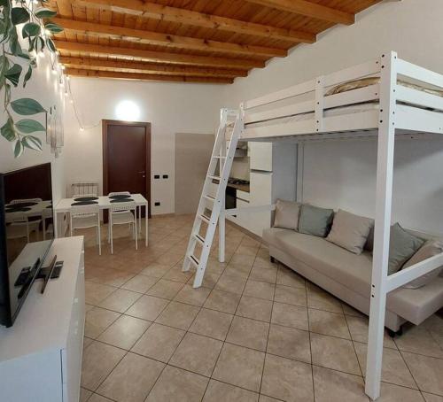 een woonkamer met een bank en een stapelbed bij Smile Home! Graziosa casa con parcheggio e giardino in Bovísio-Masciago Milanese