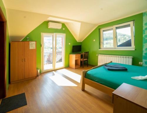 um quarto verde com uma cama e uma secretária em Vila Jovanovic em Ivanjica