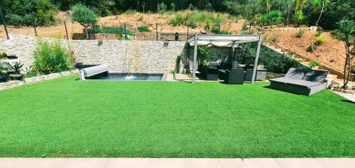 een achtertuin met een groen gazon en een zwembad bij Villa contemporaine Côte Azur Ollioules Calme in Ollioules