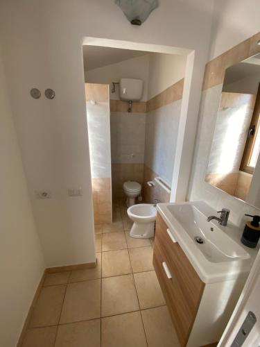 a bathroom with a white sink and a toilet at La Collina: Il maestrale in Castiadas