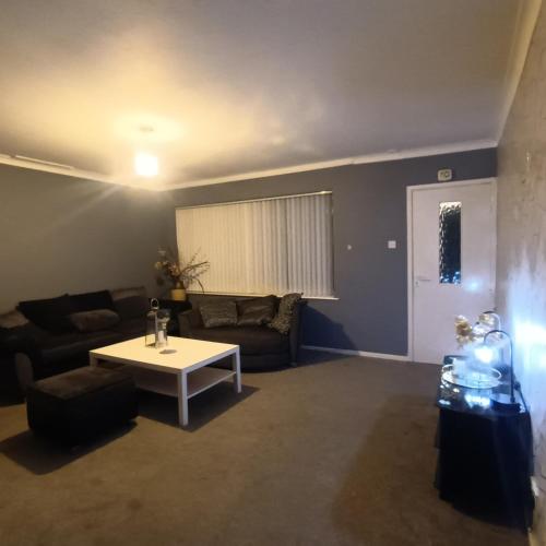 a living room with a couch and a table at 2 bed apartment in Whitefield