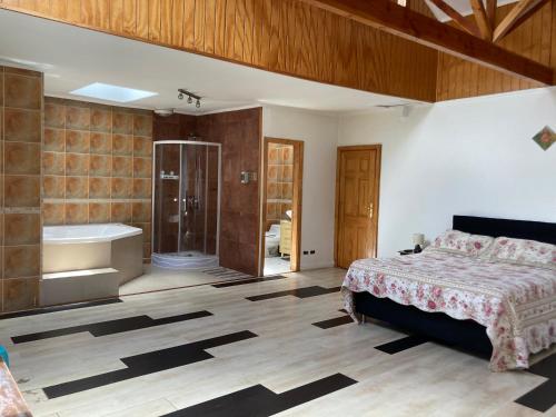 1 dormitorio con 1 cama, ducha y bañera en Amplia habitación con Jacuzzi y aire acondicionado, en Valdivia