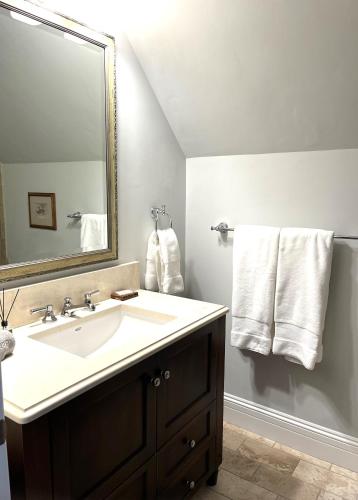 a bathroom with a sink and a mirror and towels at The Residence on South Oak - steps to the gondola! in Telluride