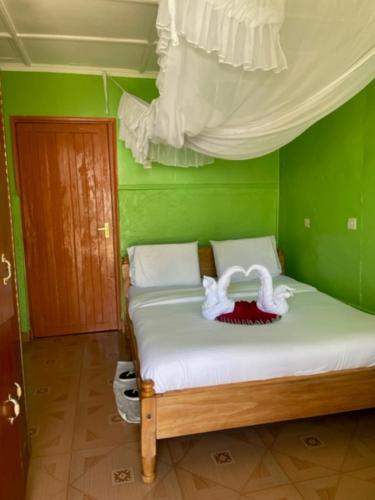 una camera verde con un letto con due cigni sopra di Jungle Green Resort, Kiutine a Meru