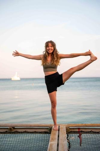 a woman standing on a dock with her legs in the air at Isla Fuerte Eco House in Isla Fuerte