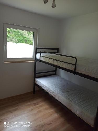 two bunk beds in a room with a window at Domki pod Sosnami in Międzychód