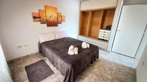 1 dormitorio con cama con chanclas en Alojamientos Litoral - Dpto San José en Gualeguaychú