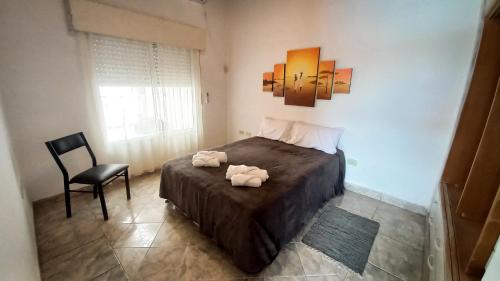 un dormitorio con una cama con dos animales de peluche en Alojamientos Litoral - Dpto San José en Gualeguaychú
