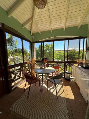 uma cozinha e sala de jantar com mesa e cadeiras em Studio Karaïbes em Sainte-Anne