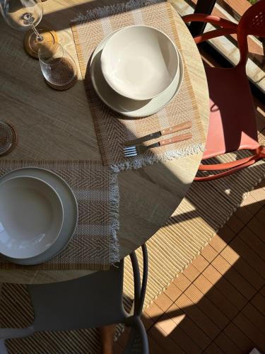 una mesa con dos platos blancos encima en Studio Karaïbes, en Sainte-Anne