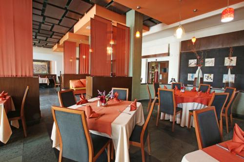 a dining room with tables and chairs and a restaurant at Hotel Colón Plaza Business Class in Nuevo Laredo