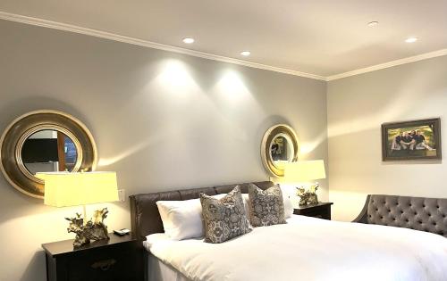 a bedroom with a bed with two mirrors on the wall at The Residence on South Oak - steps to the gondola! in Telluride