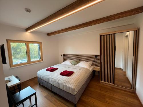 a bedroom with a bed with two red towels on it at Penzion Stará pošta in Dubí