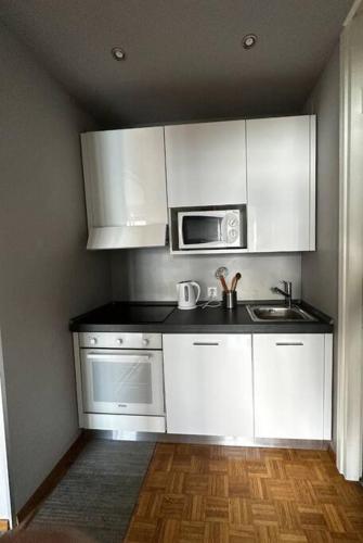 a kitchen with white cabinets and a microwave at Paradise Lake View in Paradiso