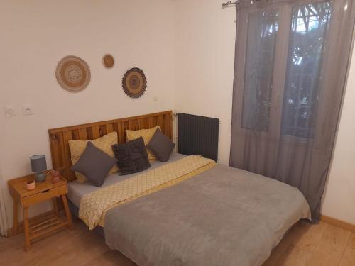1 dormitorio con cama con almohadas y ventana en Appartement all in grey, en Agen