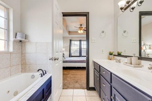 ein Badezimmer mit Badewanne, Waschbecken und Spiegel in der Unterkunft Family-Friendly Ocean Springs Home Grill, Hot Tub in Ocean Springs