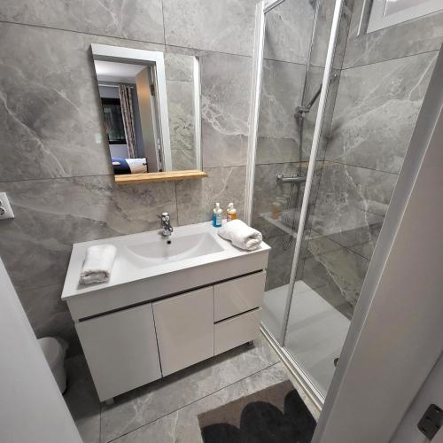 a bathroom with a sink and a shower at oeiras Lagoas Parque ,elite home in Porto Salvo