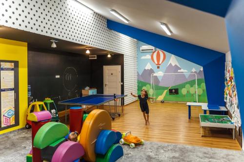 a woman standing in a room with a ping pong table at Hotel Aquarion Family & Friends - Destigo Hotels in Zakopane