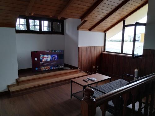 a living room with a tv and a table at oeiras Lagoas Parque ,elite home in Porto Salvo