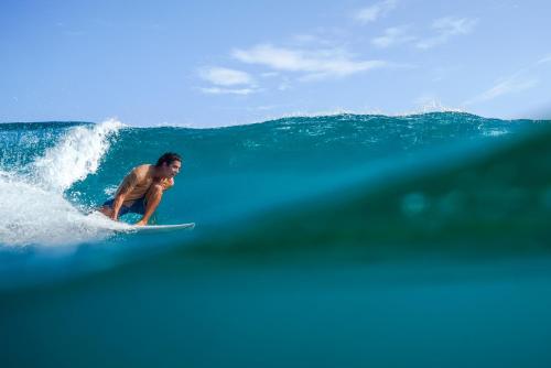 a man riding a wave on a surfboard in the ocean at Isla Fuerte Eco House in Isla Fuerte