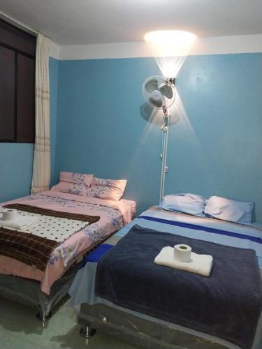 1 dormitorio con 2 camas y una lámpara con ventilador en Depa - 204, en Moyobamba