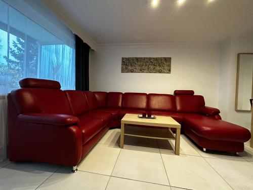 a red couch in a living room with a table at HomeZone Seelze in Seelze