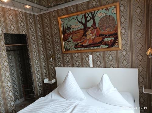a bedroom with a bed and a painting on the wall at Central Hotel in Schwetzingen