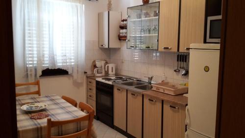 una cucina con tavolo, lavandino e piano cottura di Apartments Pero a Pola (Pula)