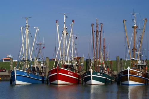 a group of boats parked in the water at Hotel Grachtenhuus Greetsiel in Greetsiel