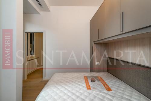 Un dormitorio con una cama con un libro. en Porta Venezia New Luxury apt - wifi full equiped, en Milán
