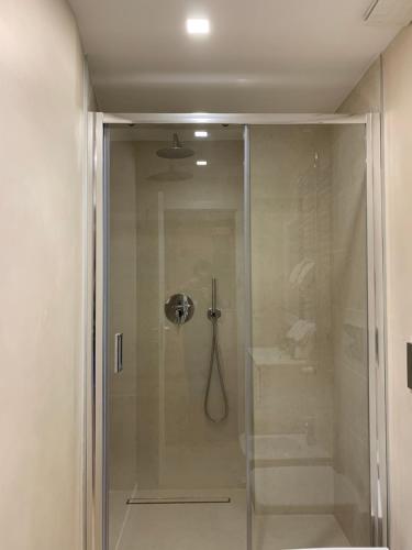 y baño con ducha y puerta de cristal. en Porta Venezia New Luxury apt - wifi full equiped, en Milán