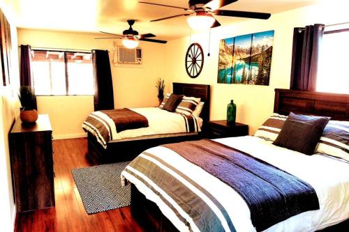 a bedroom with two beds and a clock on the wall at River Retreat Cabin in Three Rivers - near SNP in Three Rivers