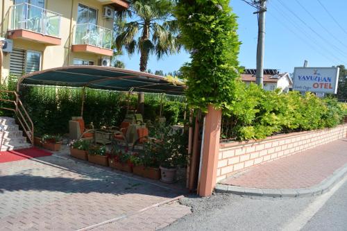 a pavilion with chairs and plants on a street at Yavuzhan Hotel in Side
