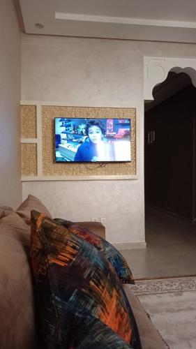 ein Wohnzimmer mit einem Sofa und einem Flachbild-TV in der Unterkunft appartement in Marrakesch