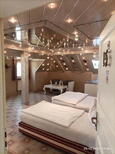 a room with two beds and a table with lights at Central Hotel in Schwetzingen