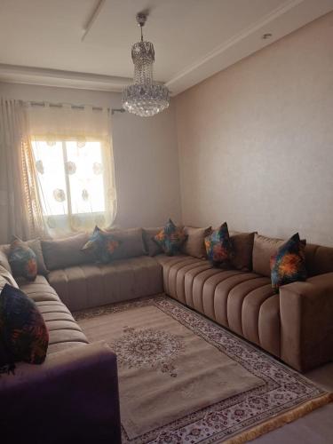 a living room with a large couch and a window at appartement in Marrakesh