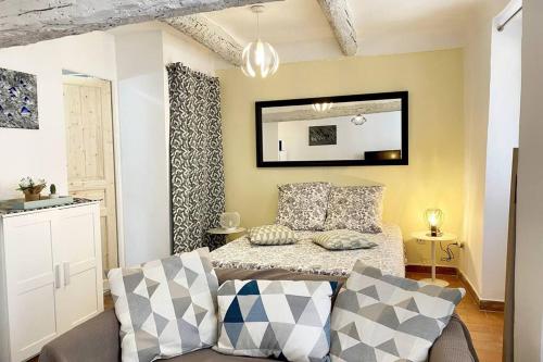une chambre avec un lit, un canapé et un miroir dans l'établissement Studio - Vieille ville - 7mn Plage - 2mn Restaurant Musée Commerce, à Antibes