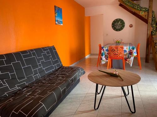 ein Wohnzimmer mit einem Sofa und einem Tisch in der Unterkunft La Terrasse du Houelmont in Gourbeyre