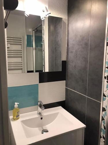 une salle de bain avec un lavabo et un miroir dans l'établissement LES DEUX ALPES, appartement vue imprenable, à Les Deux Alpes