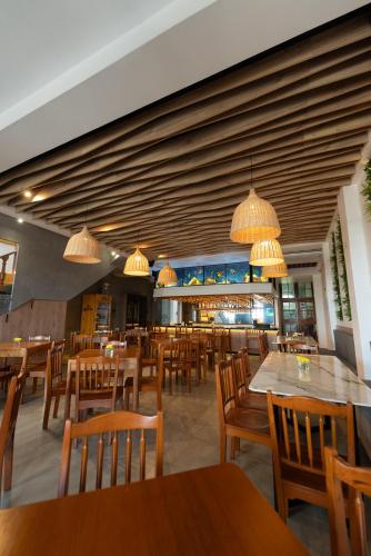 un ristorante con tavoli e sedie in legno e luci di La Estacion Gran Hotel a Pacasmayo