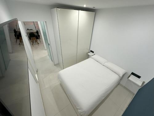 uma cama branca num quarto com um espelho em Fuente Dulce em Orzola