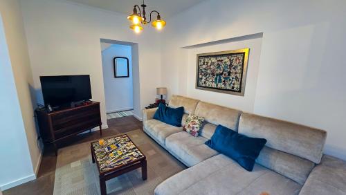 een woonkamer met een bank en een tv bij Casa da Abelheira in Ponta Delgada
