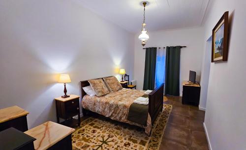 een slaapkamer met een bed en twee tafels en een televisie bij Casa da Abelheira in Ponta Delgada